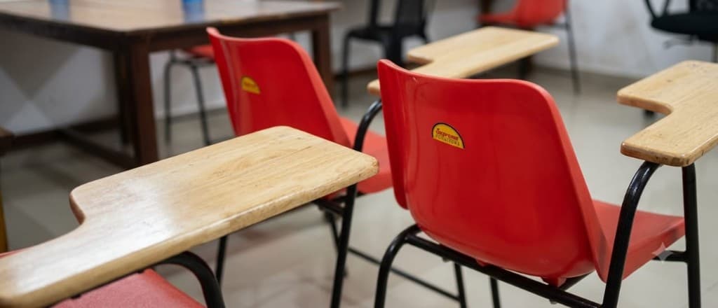 Red study chairs with attached wooden writing tablets