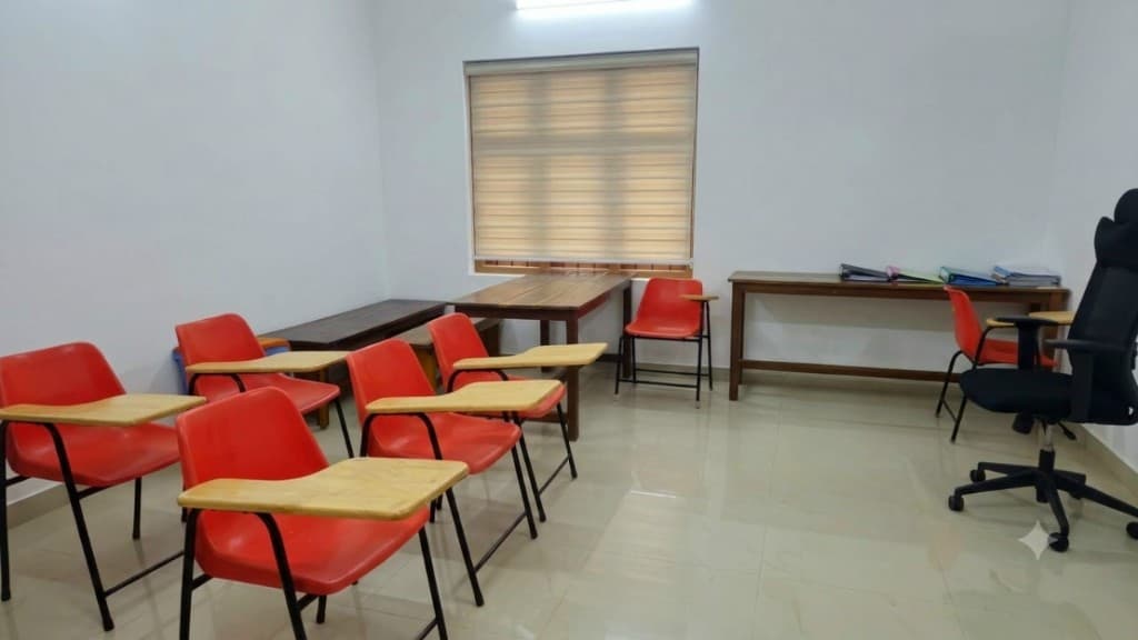 Bright study hall with writing desks, teacher desk and natural light